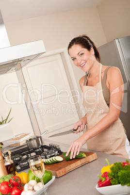 Young woman cutting zucchini in the kitchen