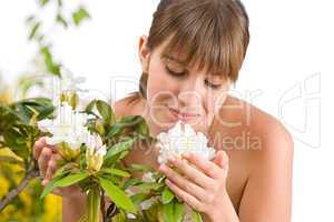 Portrait of woman smelling blossom of Rhododendron