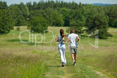 Young couple jogging outdoors in spring nature