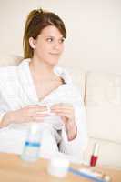 Body care - woman remove nail polish in bathrobe