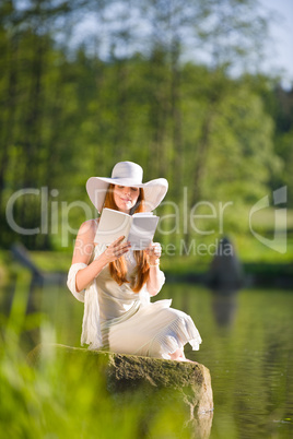 Long red hair romantic woman relax by lake with book