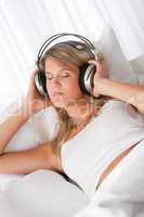 White lounge - Blond woman with headphones listening to music