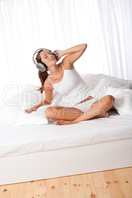 Young woman in white with headphones