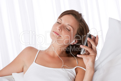 Young woman listening to music holding mp3 player