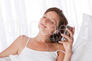 Young woman listening to music holding mp3 player