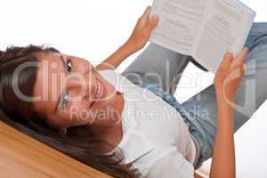 Brown hair teenager lying down holding book