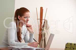 Long red hair woman working at office with laptop