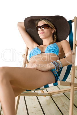 Beach - Young woman in bikini sitting on deck chair