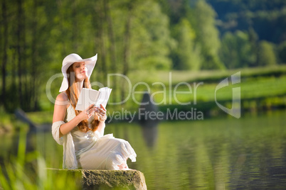 Long red hair romantic woman relax by lake with book
