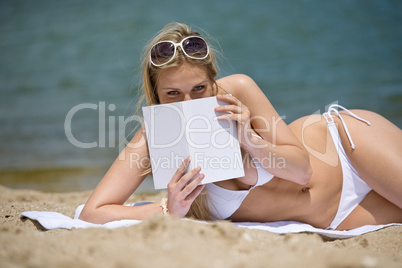 Blond woman relax on beach with book