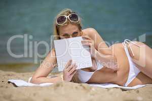 Blond woman relax on beach with book