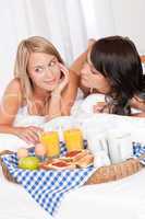 Two happy young women having breakfast