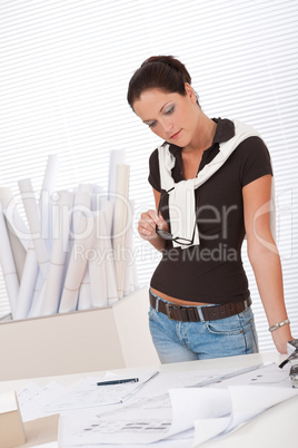 Young female architect studying plans at the office