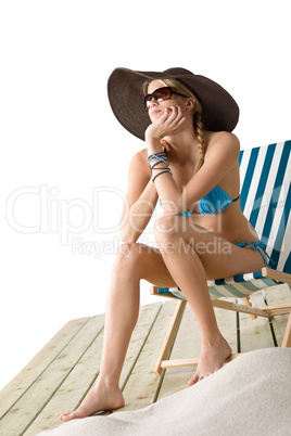 Beach - Young woman in bikini sitting on deck chair