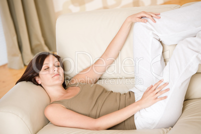 Young happy woman relax lying down on sofa