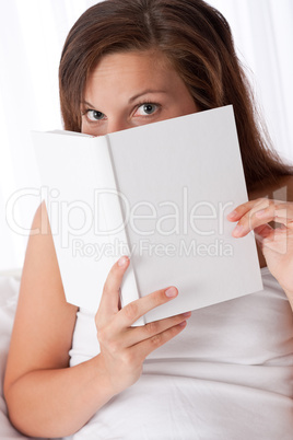 Woman peeking over white book