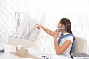 Female architect calling with phone at the office