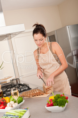 Woman cutting bread in the kitchen