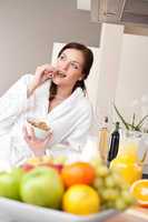 Happy woman eat cereals for breakfast in kitchen
