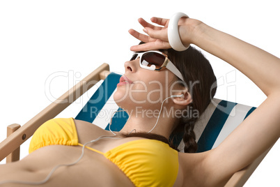 Beach - Woman with ear buds sunbathing in bikini