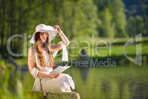 Long red hair romantic woman relax by lake with book