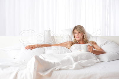 White lounge - Blond woman holding cup of coffee