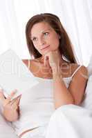 Woman thinking while reading book