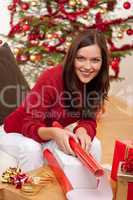 Young woman packing Christmas present