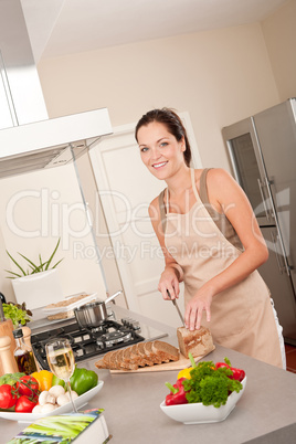 Woman cutting bread in the kitchen