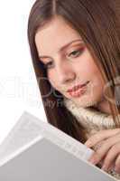 Portrait of young happy woman with book wearing turtleneck