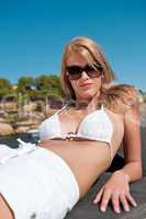 Blond woman sunbathing on luxury yacht with bikini