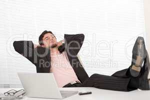 Successful businessman in black suit relaxing at office