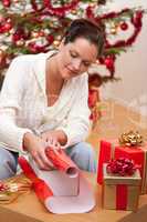 Young woman packing Christmas present