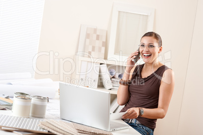 Young female designer on the phone at office