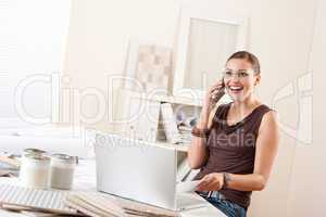Young female designer on the phone at office
