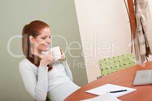 Long red hair woman at office with coffee