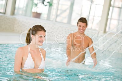 Swimming pool - young couple have fun under water stream