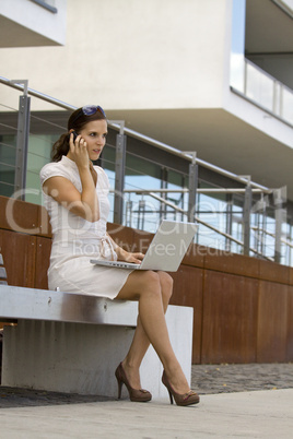 Female trading wireless outside on a bench