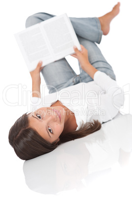 Smiling teenager lying down and reading book