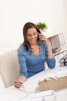 Young female architect working at office holding phone