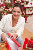 Young woman packing Christmas present