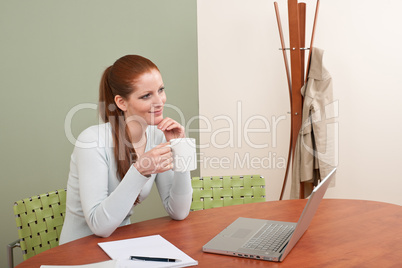 Red hair woman with cup of coffee at office