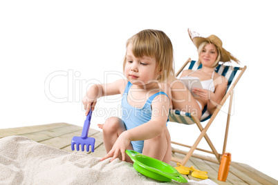 Beach - Mother with child playing with toys in sand