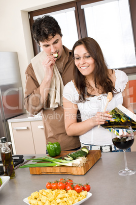 Smiling couple in modern kitchen cook together