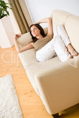 Young happy woman relax lying down on sofa