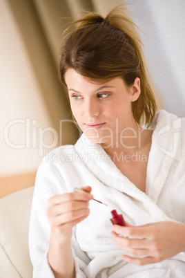 Body care - woman polish nail in bathrobe