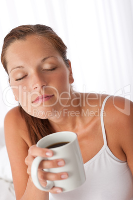 Beautiful young woman holding cup of coffee