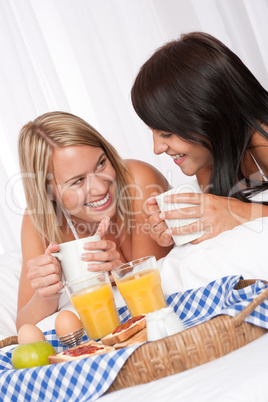 Two young smiling woman drinking coffee