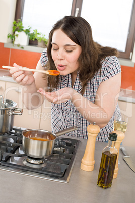 Cook - plus size woman tasting Italian tomato sauce