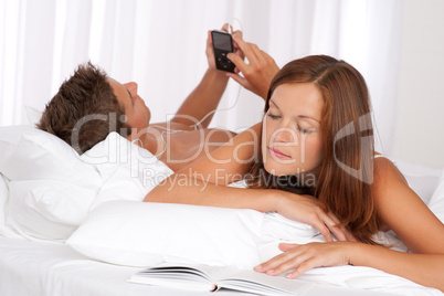Young man and woman lying down in bed